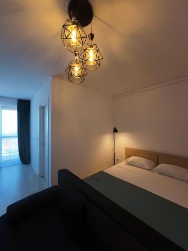 a bedroom with a bed and a chandelier at Lovely Sunrise in Bucharest