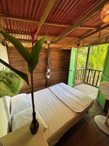 a room with a bed and a vase with a plant at La Roca House in El Valle