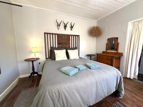a bedroom with a large bed with two pillows at Rus n Bietjie Guest House in Loxton