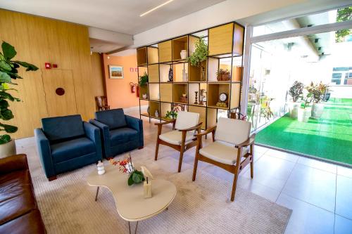 a living room with a blue couch and chairs at MLG Hotel in Mogi das Cruzes