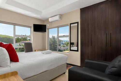 a bedroom with a bed and a tv and a couch at 51 Dolphin Drive in Cape Town