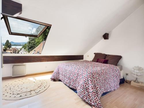 ヴェリエ・デュ・ラックにあるDuplex face au lac d'Annecyのベッドと大きな窓のある寝室