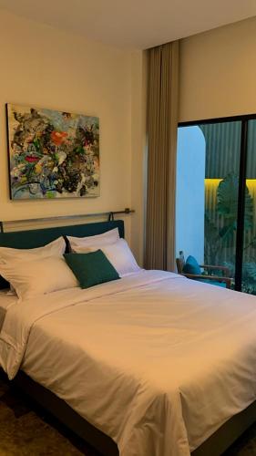 a bedroom with a large white bed with a window at Manta Rooms in Yogyakarta