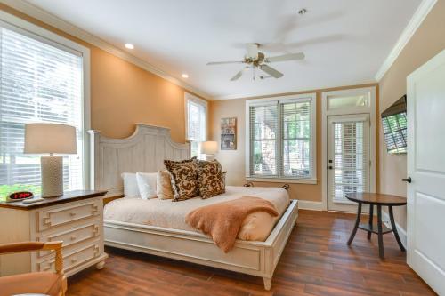 a bedroom with a bed with a dresser and windows at Lake Oconee Creekside Condo with Dock Access in Liberty