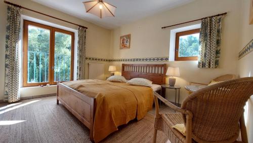 Un dormitorio con una cama y dos ventanas. en Freundliches Haus mit Pool und großem Garten, en Buis-les-Baronnies
