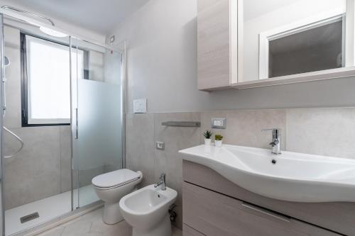 Un baño blanco con lavabo e inodoro. en Loft Ticinese with Wi-Fi and Netlfix, en Milán