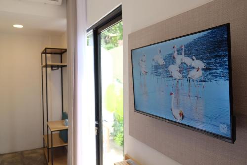 een flatscreen-tv die aan de muur hangt bij Manta Rooms in Sentool