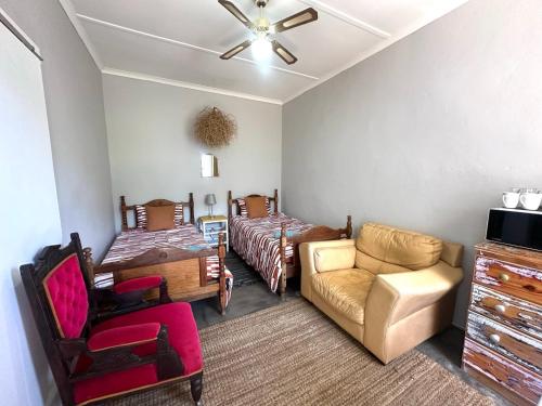 a living room with two beds and a couch at Rus n Bietjie Guest House in Loxton