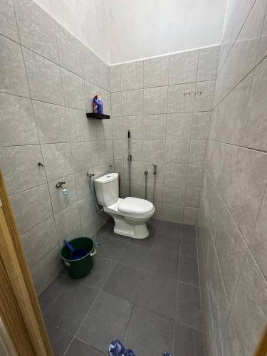a bathroom with a toilet and a bucket in it at Zarul Homestay in Bachok