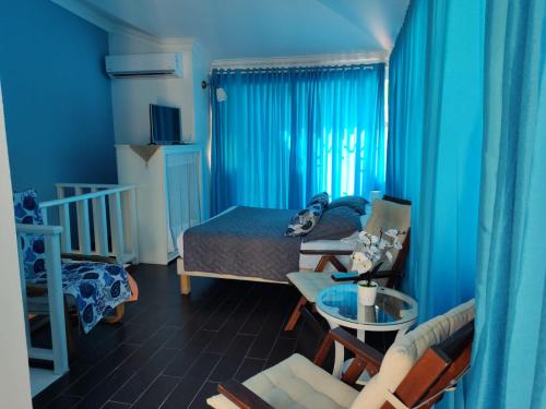 a blue room with a bed and a table and chairs at Las Palmeras RIKI R in Boca Chica