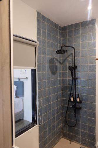 een badkamer met een douche en een blauwe tegelmuur bij Manta Rooms in Sentool