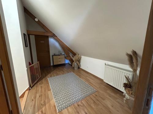 une chambre mansardée avec un escalier et un couloir avec un tapis dans l'établissement Jolie maisonnette, à Barenton-Bugny