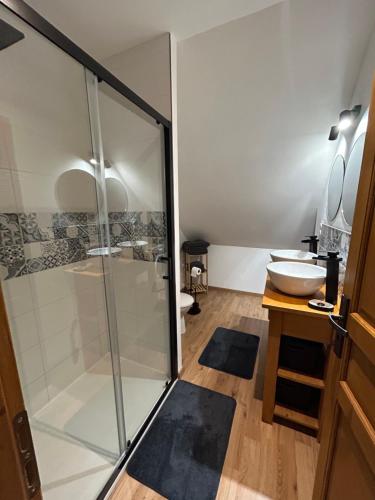 a bathroom with a glass shower and a sink at Jolie maisonnette in Barenton-Bugny