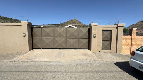 a garage door in a house with a car parked in front at Homes by Palesa in Maseru