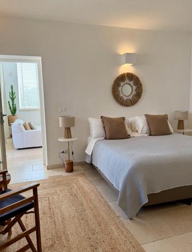 a white bedroom with a bed and a mirror at Boutique B&B Villa Gufo in Ostuni