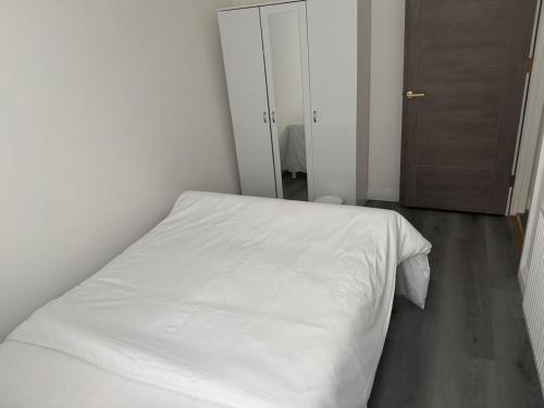 a white bed in a white bedroom with a door at Three-Bedroom Flat Located off Oxford Street in London