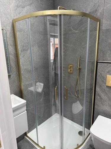 a shower with a glass door in a bathroom at Three-Bedroom Flat Located off Oxford Street in London