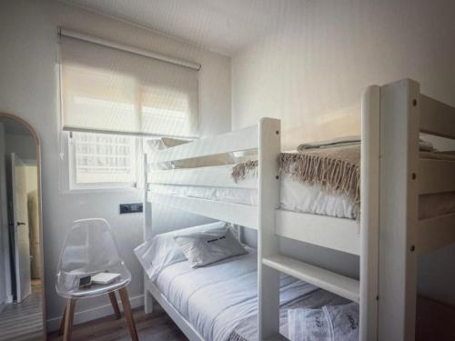 Un dormitorio con dos literas y una silla. en Newly renovated apartment in Málaga, en Málaga