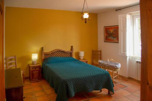 a bedroom with a bed with a green comforter at Quinta do Céu Tranquilidade e Piscina no Alentejo in Alvito