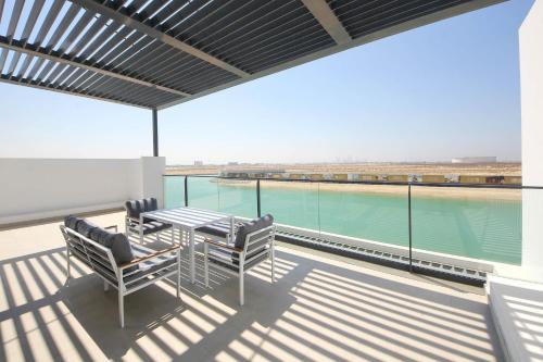 a balcony with a table and chairs and a view of the water at Silk Valley - 4B near Al Hamriyah | private beach access in Sharjah