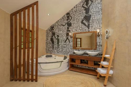 a bathroom with a tub and a sink and a mirror at Turaco Ngorongoro Valley, a Tribute Portfolio Lodge in Karatu
