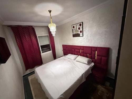 a small bedroom with a bed with a red headboard at Saaid Mouadin in Casablanca