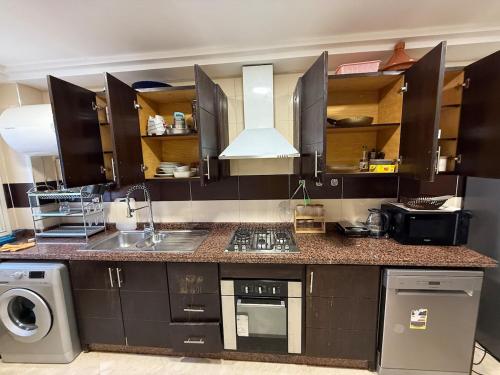 a kitchen with a sink and a stove top oven at Saaid Mouadin in Casablanca