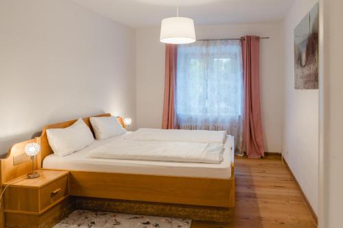 une petite chambre avec un lit et une fenêtre dans l'établissement Ferienwohnung Jelen - Kaffee - Tee - Lichthof - 135 qm, à Kolbermoor