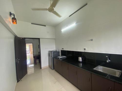 a kitchen with a sink and a black counter top at DOWN TOWN HOLIDAYS Kovalam in Kovalam