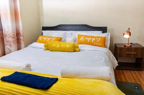 a bed with orange and blue pillows on it at Micasa Pent House MAIN in Limuru