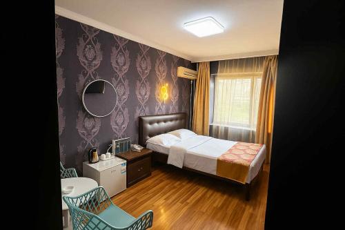a bedroom with a bed and a mirror and a chair at Evergreen Hotel in Ulaanbaatar