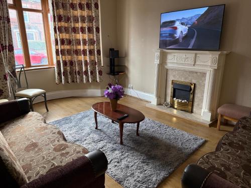 a living room with a fireplace and a tv at EN-SUITE Luxurious Room in Nottingham