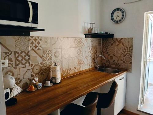 een aanrecht met een wastafel en een klok aan de muur bij SPA ROOM SICILIA - Intera casa con spa privata Jacuzzi Sauna Bagno di Vapore in Rosolini