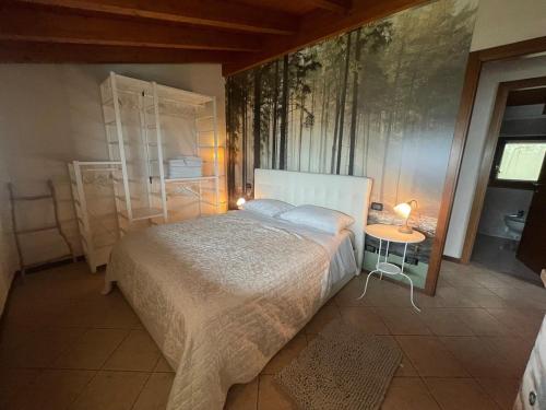 Un dormitorio con una cama en una habitación con árboles en la pared. en Ronco Frati, piscina vista lago, en Pisogne