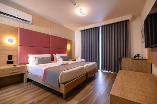 a bedroom with a large bed and a large window at C'est La Vie Boutik Swieqi in Is-Swieqi