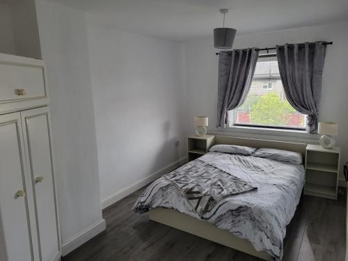 een slaapkamer met een bed en een raam bij Comfy Home in Kirkby