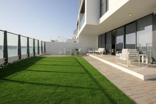 a patio with green grass on the side of a building at Silk Valley - 4B near Al Hamriyah | private beach access in Sharjah