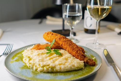 um prato de comida numa mesa com um copo de vinho em Hotel Minas Gerais em Poços de Caldas