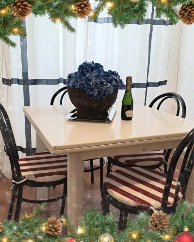 a table with a bottle of wine and a basket of flowers at Blue Breeze Apartment in Germignaga