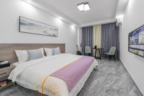 a bedroom with a large bed and a table at Park Hotel in Xiamen
