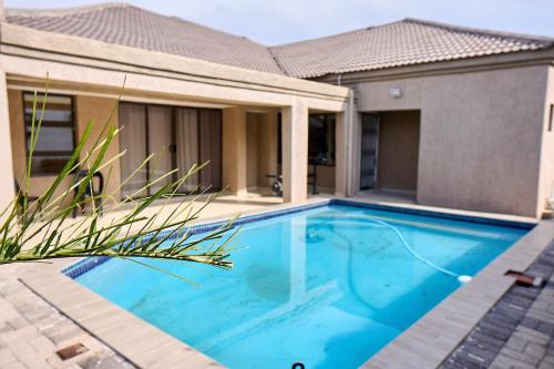 a swimming pool in front of a house at Tsholofelo East Guesthouse in Gaborone