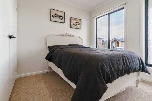a bedroom with a bed and a large window at Contemporary Comfort Brand New Deanside Retreat in Caroline Springs