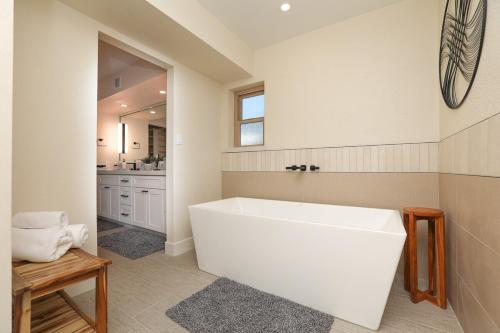a white bath tub in a bathroom with a sink at Black Mountain Gem! Designer Completely Renovated! in Cave Creek