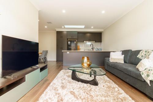 a living room with a couch and a table at Contemporary Comfort Brand New Deanside Retreat in Caroline Springs