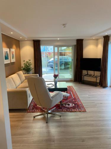 a living room with a couch and a chair at Modern apartment with mountain and sea view in Svolvær
