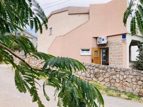 ein Haus mit einer Steinmauer und einem Gebäude in der Unterkunft Ferienhaus mit Pool für bis zwölf Personen und 200m vom Meer in Cesarica