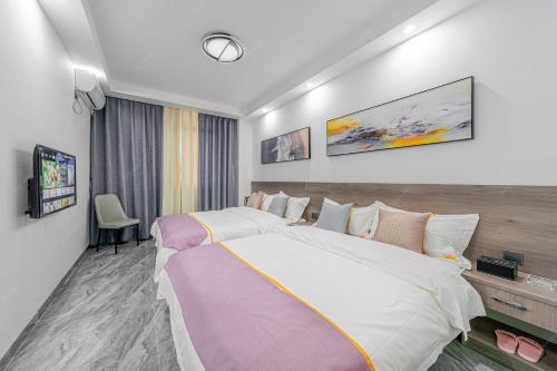 a hotel room with a large bed and a tv at Park Hotel in Xiamen