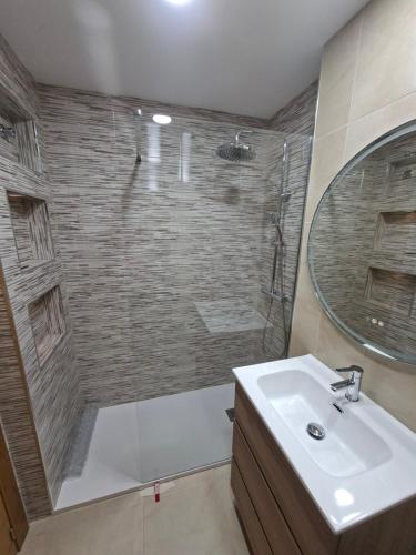 ein Badezimmer mit Dusche, Waschbecken und Spiegel in der Unterkunft Hacienda Riquelme Golf Resort, Atlantico 188, Ground Floor Apartment in Sucina