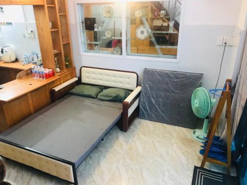 a bed in a room with a desk and a window at Homestay Bảo Nhi in Chợ Phước Hải