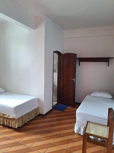 a room with two beds and a wooden floor at Hospedaria San Remo Belém in Belém